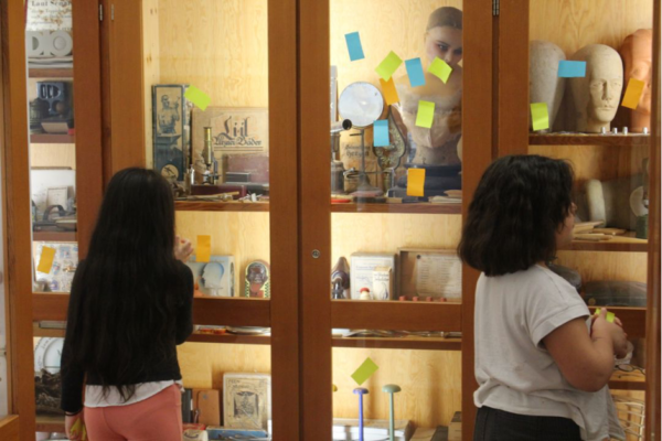 Veranstaltungsfoto, zwei Kinder vor einer Vitrine aus Holz und Glas, an dem verschiedenfarbige Post-Its kleben