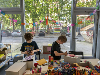 Zwei Kinder hinter einem Tisch beim Basteln