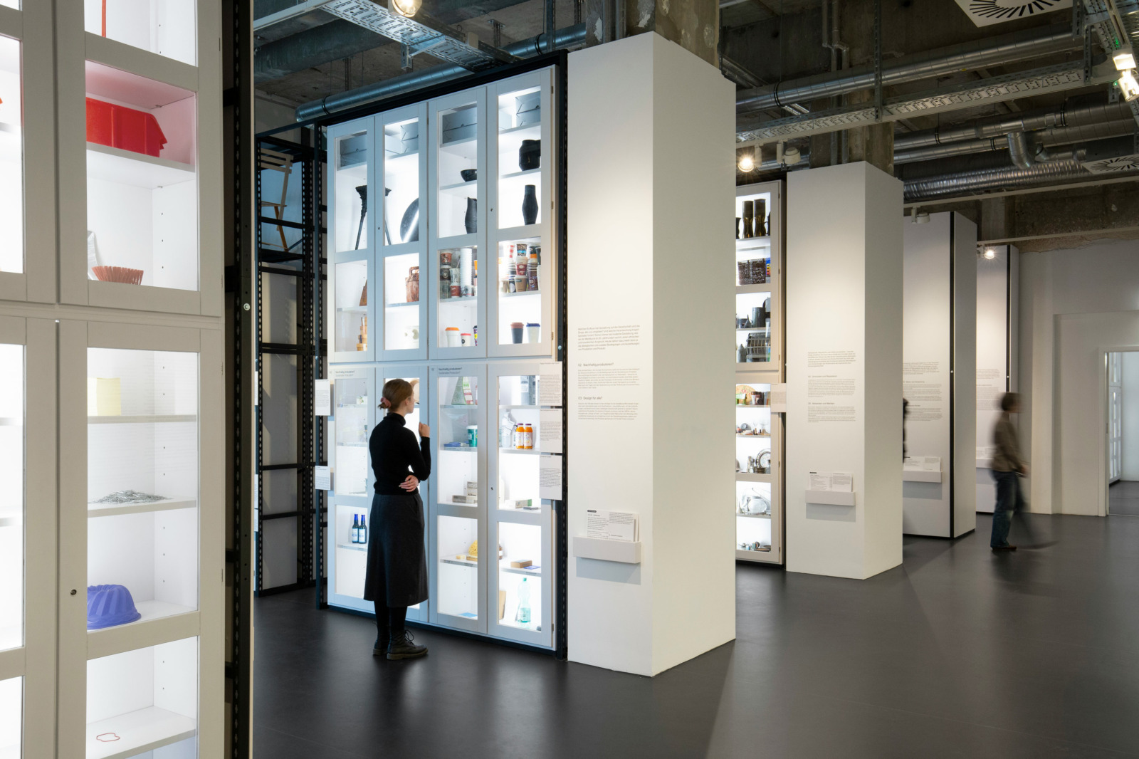Eine Besucherin steht vor einer weißen Vitrine der neuen Dauerausstellung