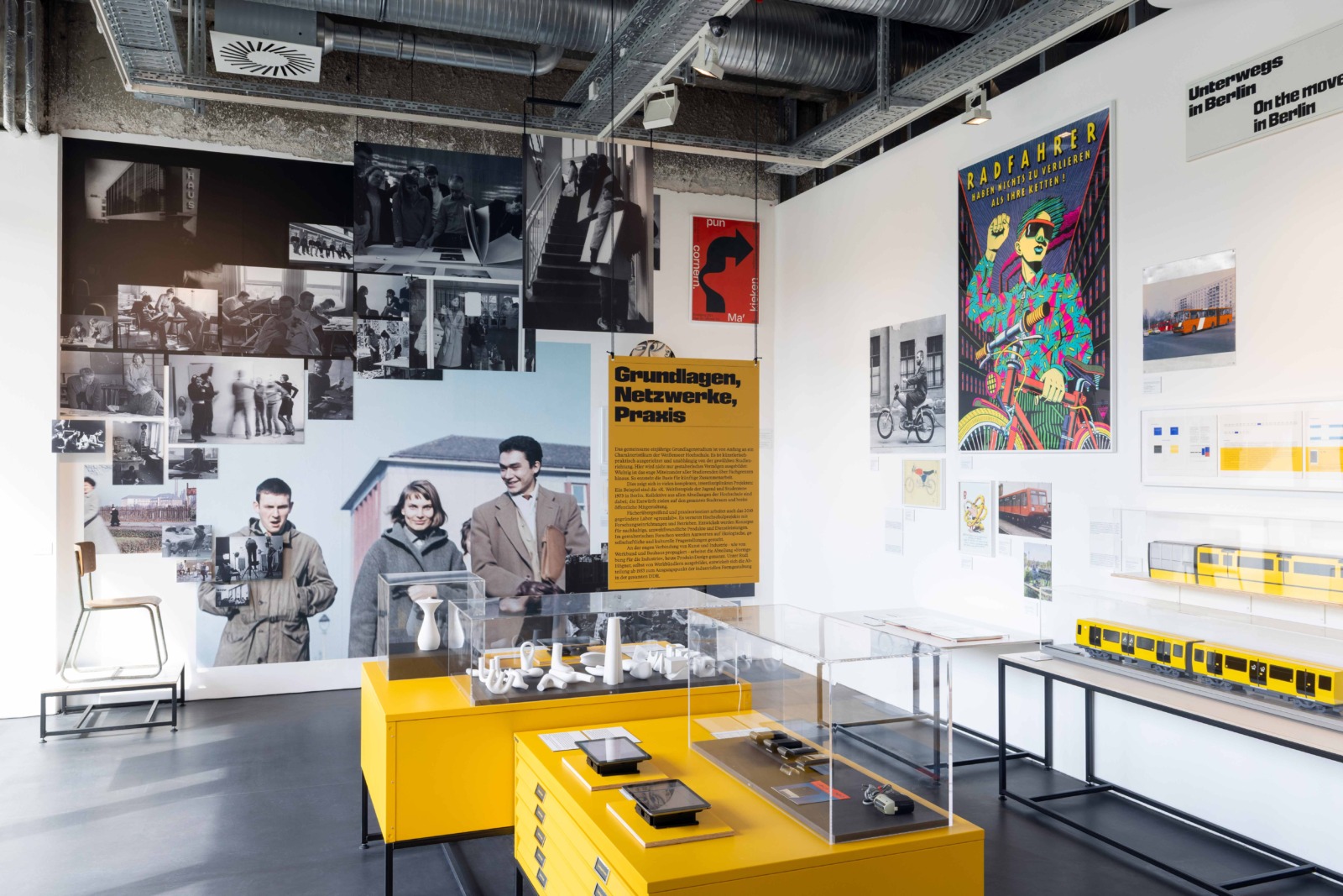 Ausstellungsansicht mit verschiedenen Exponaten, sowie großformatigen historischen Fotografien