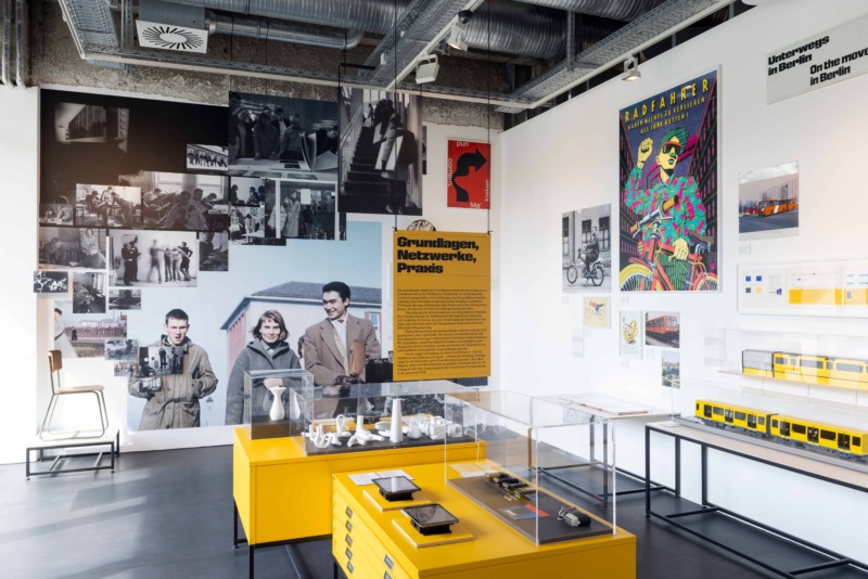 Ausstellungsansicht mit verschiedenen Exponaten, sowie großformatigen historischen Fotografien